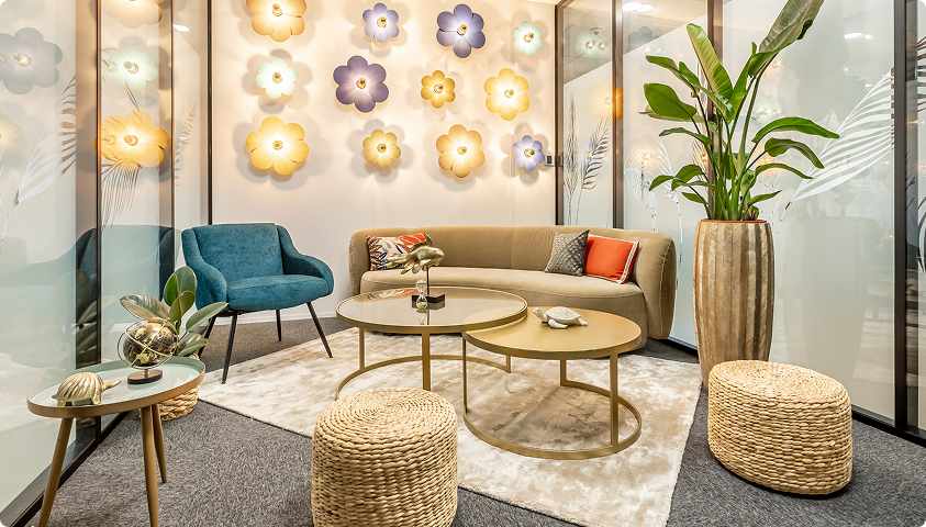 Espace lounge décoré du Trigone B’Coworker à Angers, avec canapé, fauteuil, tables basses et plantes d’intérieur.