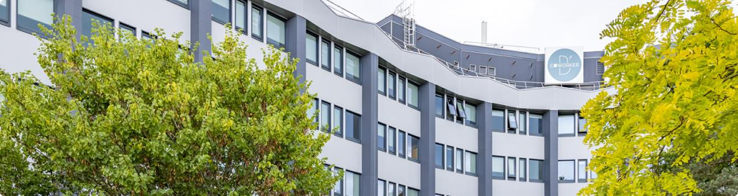 Vue extérieure du bâtiment Trigone B’Coworker à Angers, entouré d’arbres et de végétation - BMG Fonciere & B'CoWorker