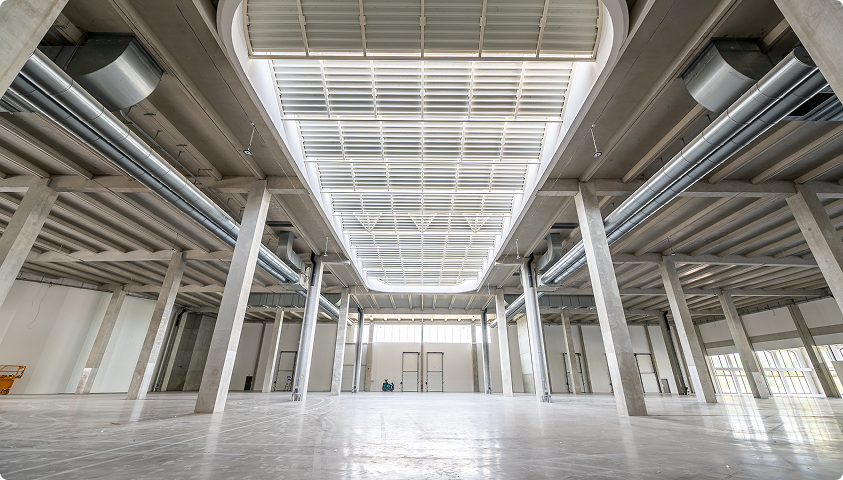 Grand espace intérieur de Imaginarium à Wasquehal, avec structure apparente, colonnes et plafond technique.