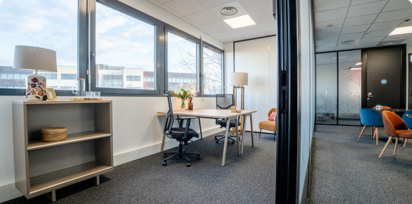 Vue intérieure du centre B’Coworker à Lille, avec bureau aménagé, espace détente, fauteuils colorés et parois vitrées.