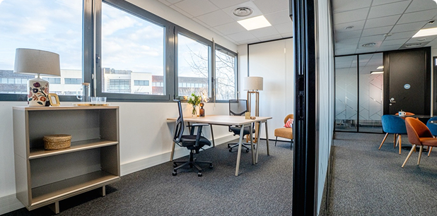 Vue intérieure du centre B’Coworker à Lille, avec bureau aménagé, espace détente, fauteuils colorés et parois vitrées.