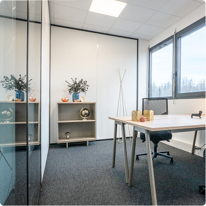 Bureau cloisonné du centre B’Coworker à Lille, aménagé avec table de travail, fauteuil, rangement et décoration.