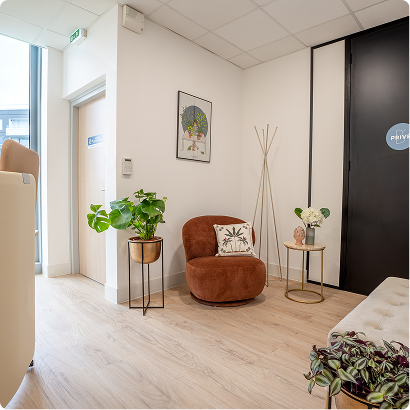 Espace détente du centre B’Coworker Lille Sud, avec fauteuil, plantes, table d’appoint et décoration murale.